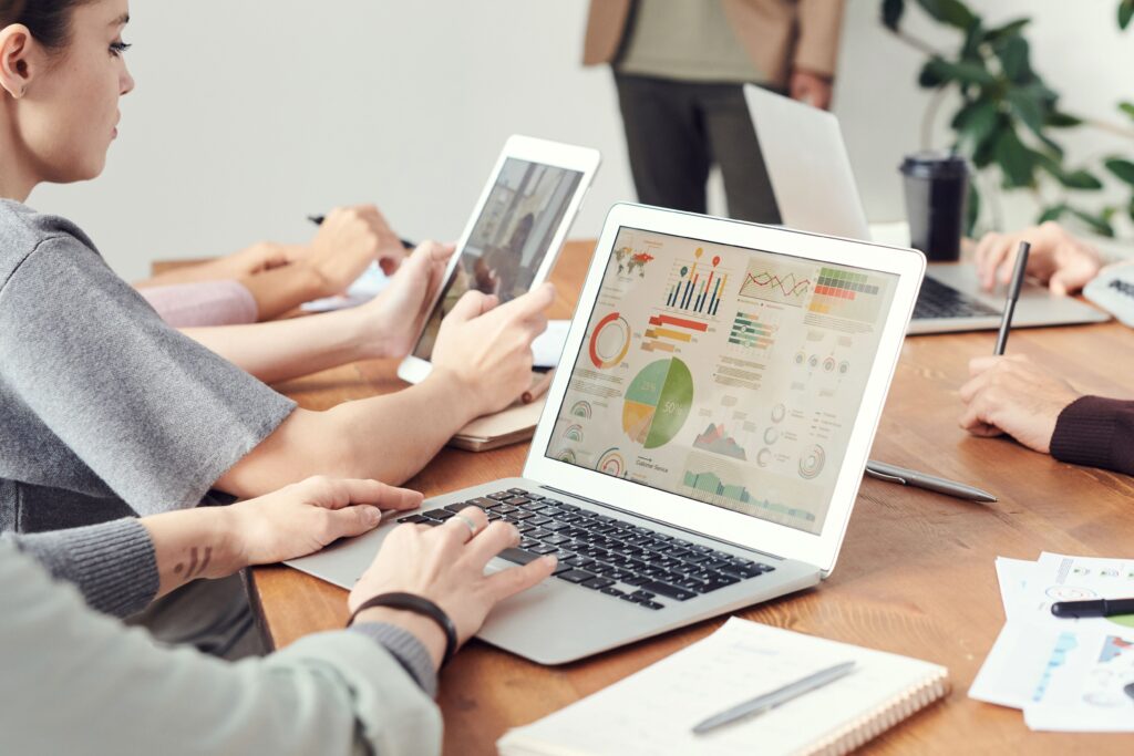 The power of social media marketing: strategies for growing your brand online Coworkers analyzing data charts on laptops during a team meeting.